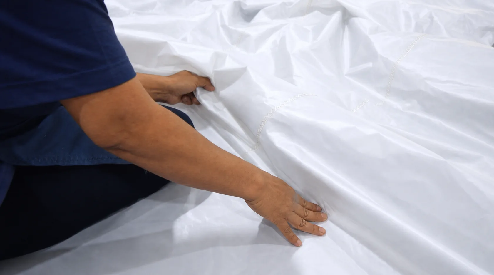 Sailcloth inspected by hand under clear workshop light
