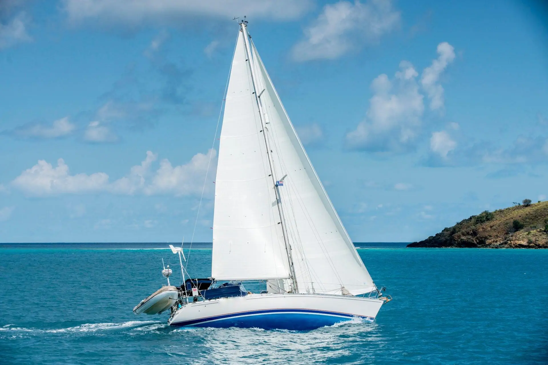 Cruising yacht sailing with a durable white mainsail